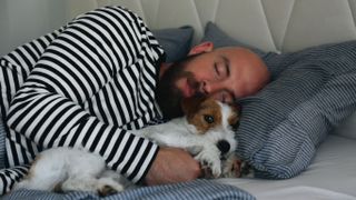 Man and dog in bed together