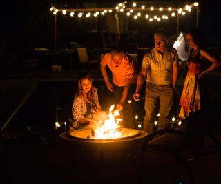 People toasting marshmallows around a fire pit