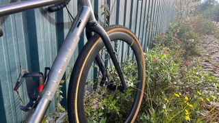 Front wheel of Ribble Gravel Ti Pro bike against fence