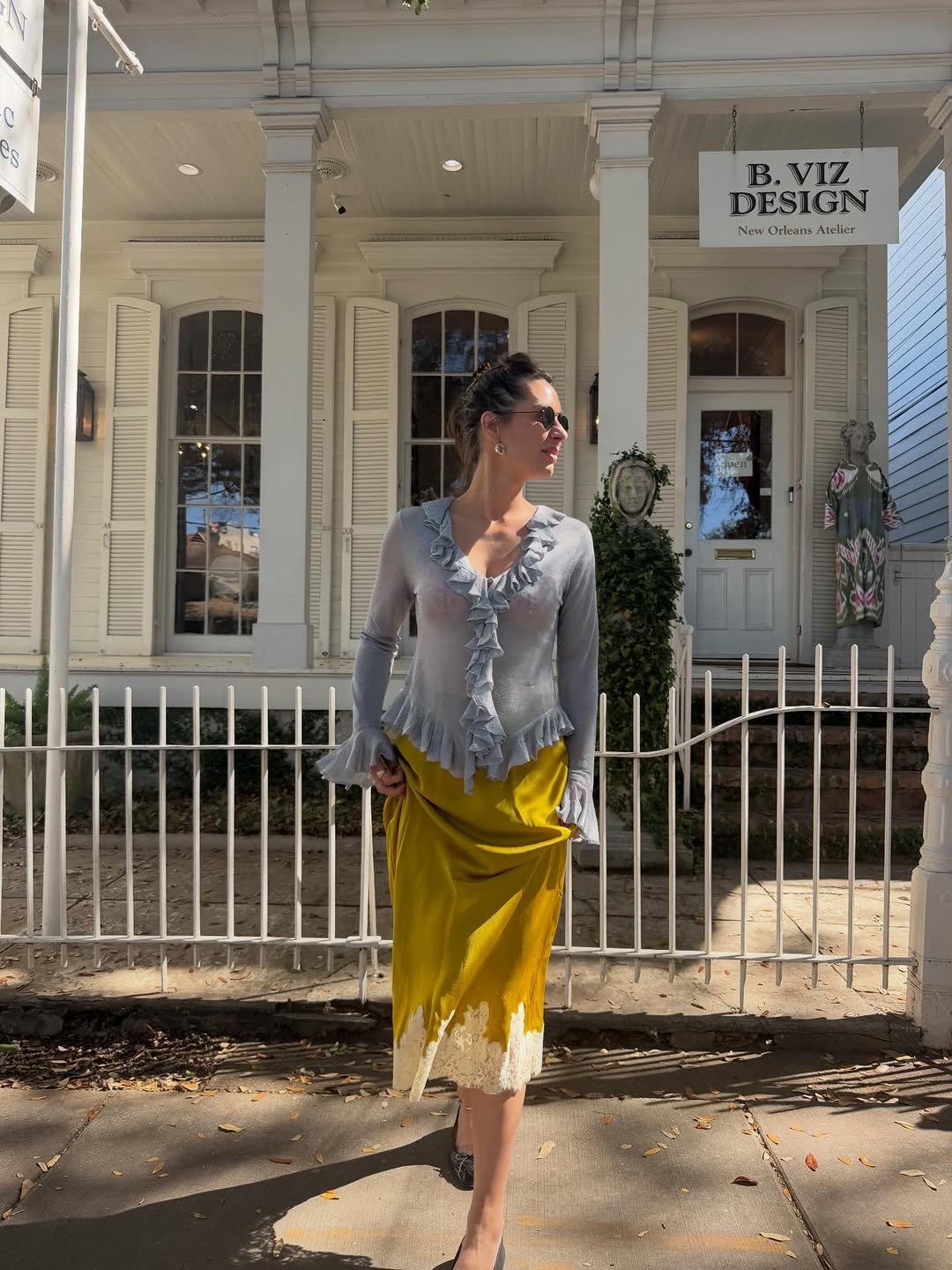 A woman wearing a baby blue blouse and mustard yellow slip skirt, one of the biggest 2026 spring color pairings.