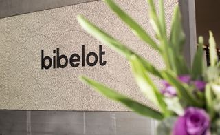The word "bibelot" in black, against a cream background made out of mosaic tiles