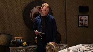 Mike holding a photo frame and looking menacing