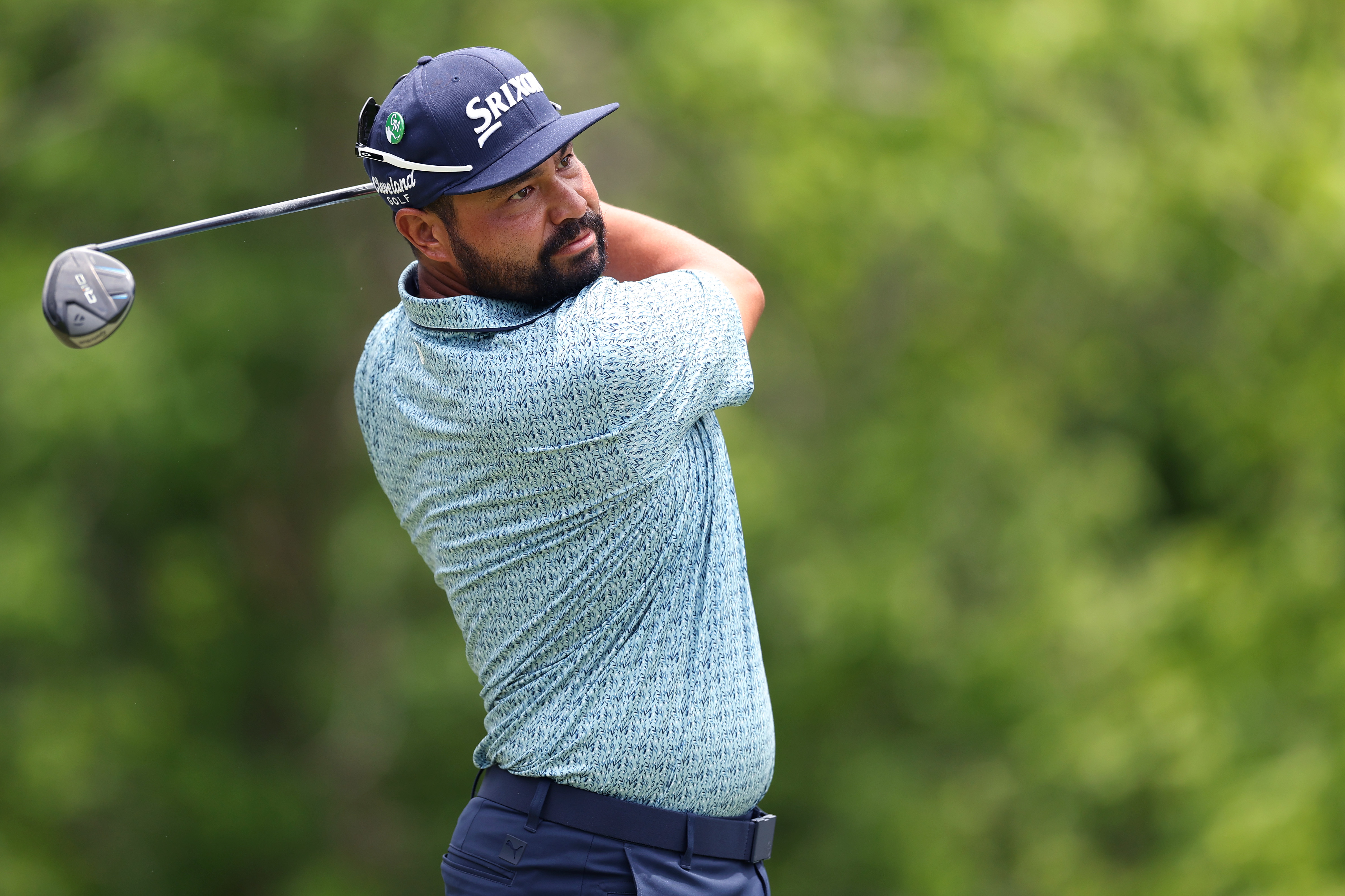 J.J. Spaun hits a fairway wood off the turf