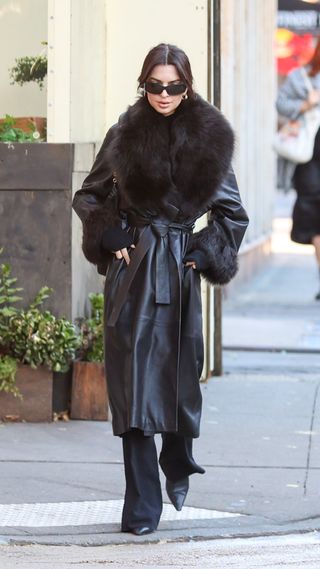 EmRata wearing a shearling-lined long leather coat