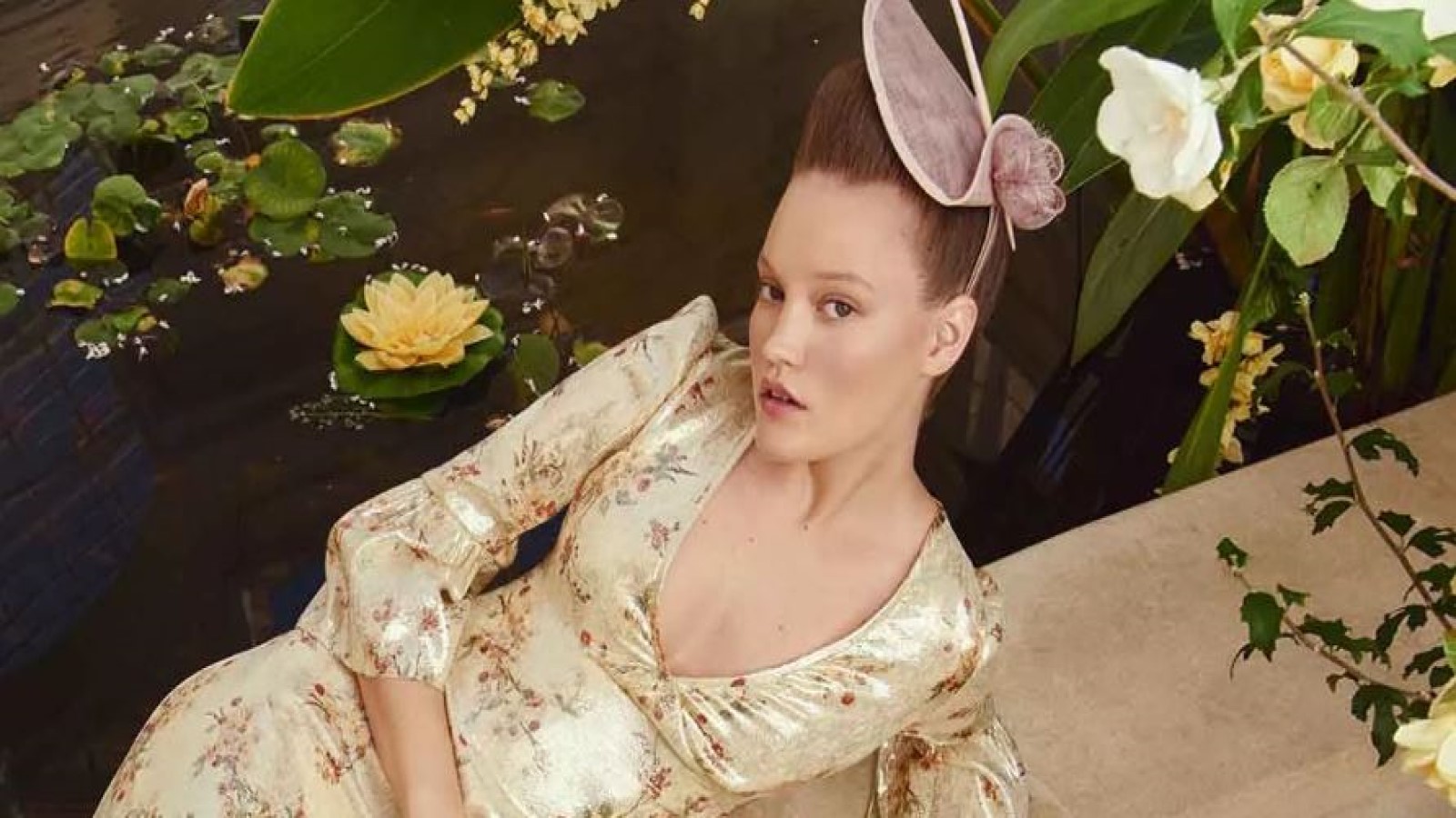 A woman posing in an LK Bennett cream satin floral dress