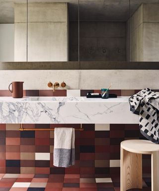 midcentury bathroom with marble vanity and brown floor tiles