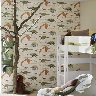 room with dinosaur wallpaper pillows and teddy
