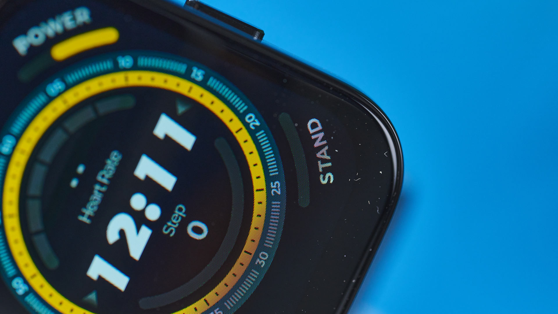 a black fitness tracker Amazfit Bip 5 showing the default yellow and blue toned watch face and fitness capabilities