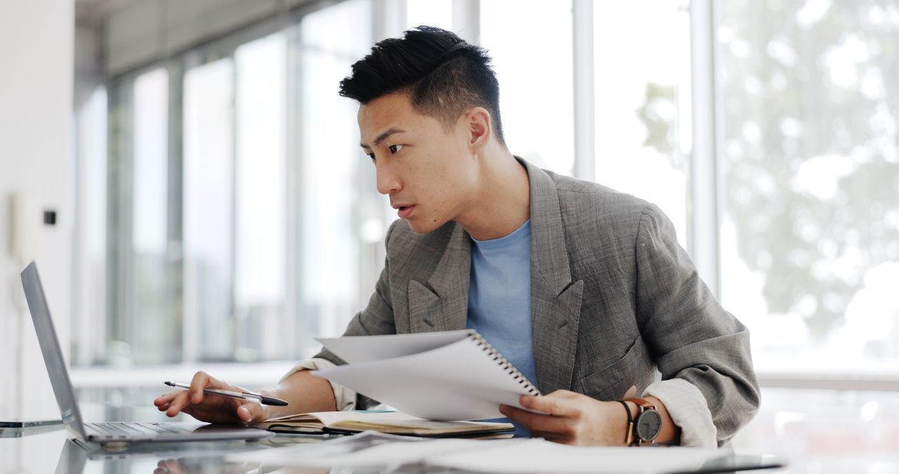 Businessman, writing report and documents with business plan proposal in conference room and company strategy in Japan. Employee focus, Asian man working with notes and pen, development and growth