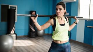 Woman performs barbell rotation