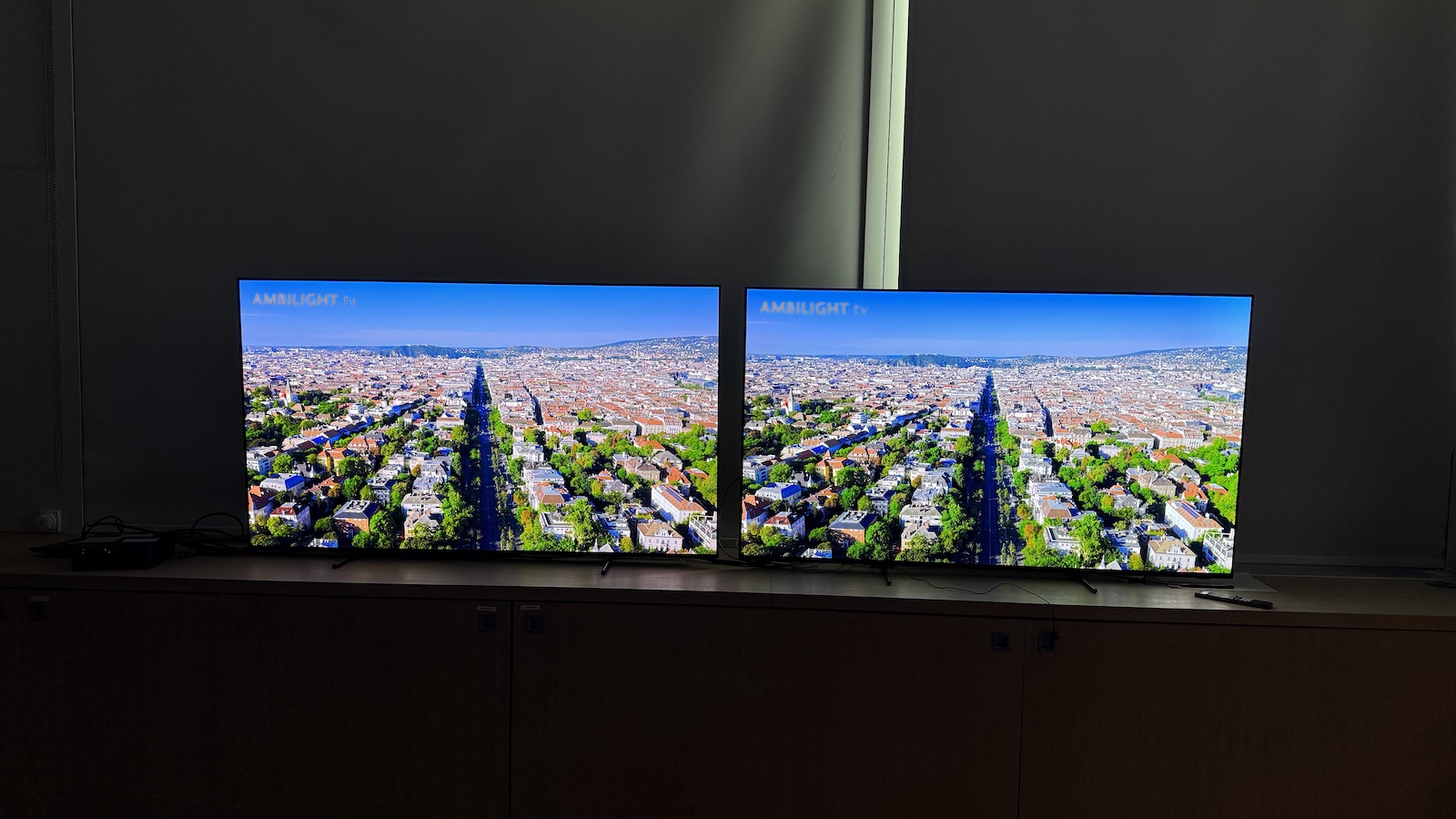 The 65-inch Philips OLED951 TV pictured alongside the 65-inch Philips OLED950. On both screens is the same scenery shot.