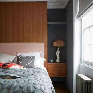 bedroom with grey and wooden wall bed with designed cushion and window