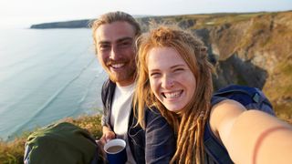 Young happy hiking couple taking self portrait on an Atlantic coastline