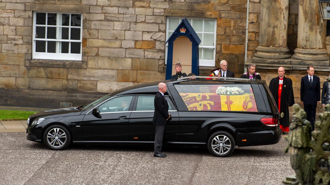 The queen&#039;s coffin, draped in the royal standard flag and a white wreath of flowers