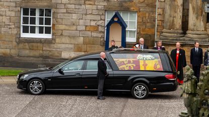 The queen's coffin, draped in the royal standard flag and a white wreath of flowers