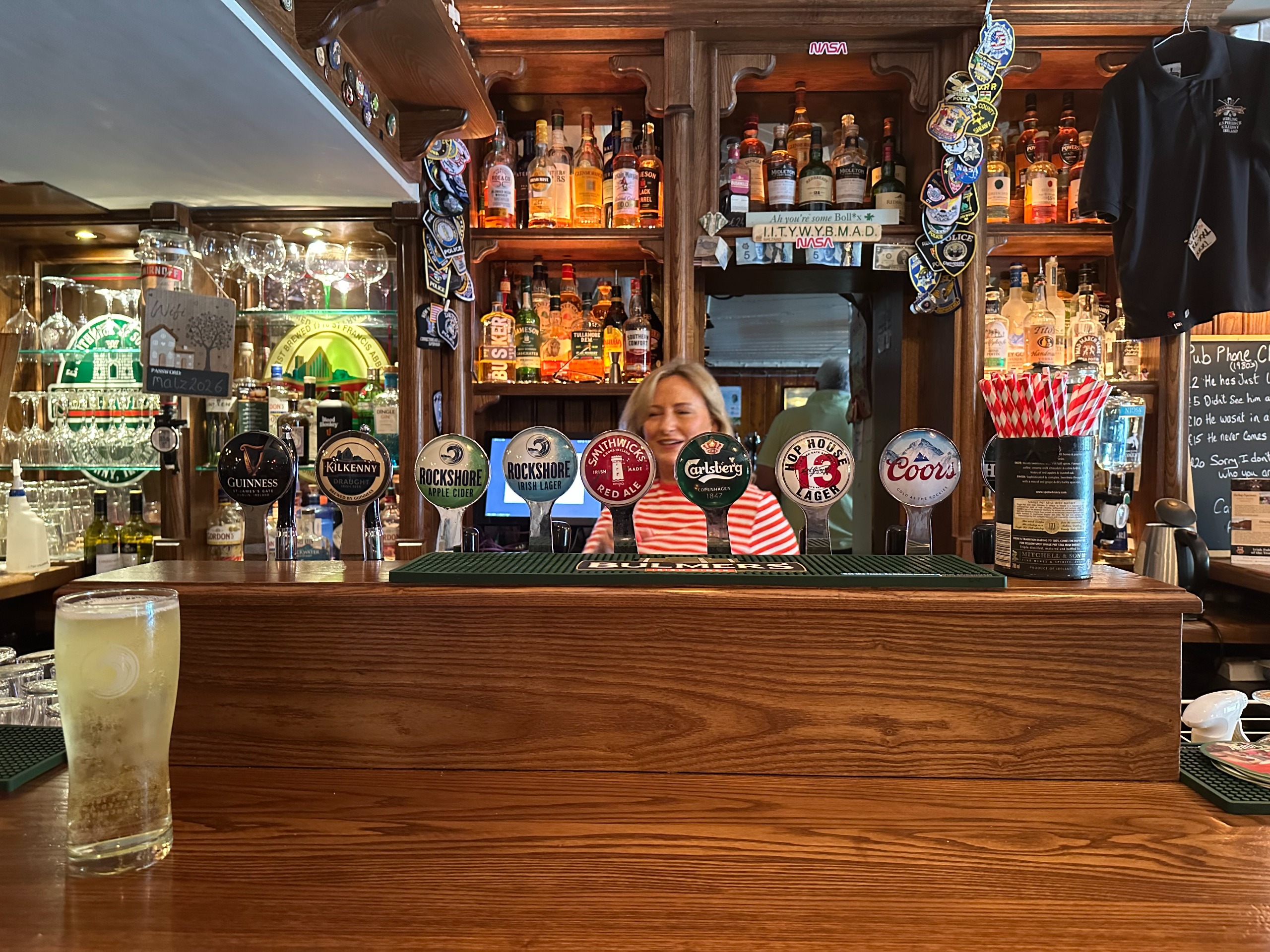 A woman stands behind the counter at Malzard's Pub in Ireland