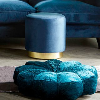 blue coloured velvet footstool and cushion