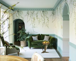 living room with green velvet sofa and chair, trailing ivy wallpaper and aqua woodwork