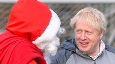 Boris Johnson speaks with a man dressed as Father Christmas in 2019