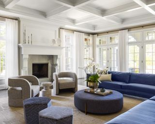 Large white, blue and gray living room, lots of seating gathered around fireplace