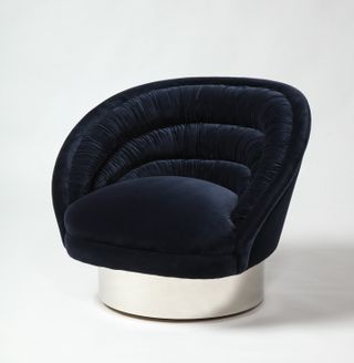 Blue velvet armchair with metal base shaped like a disc