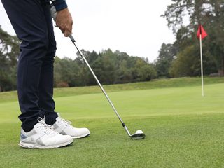 man chipping with golf ball