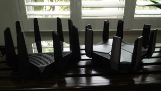 ASUS ROG Rapture GT-AXE16000 quad-band Wi-Fi 6E router with a TP-Link Archer AXE300