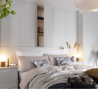 White bedroom with storage on wall above bed