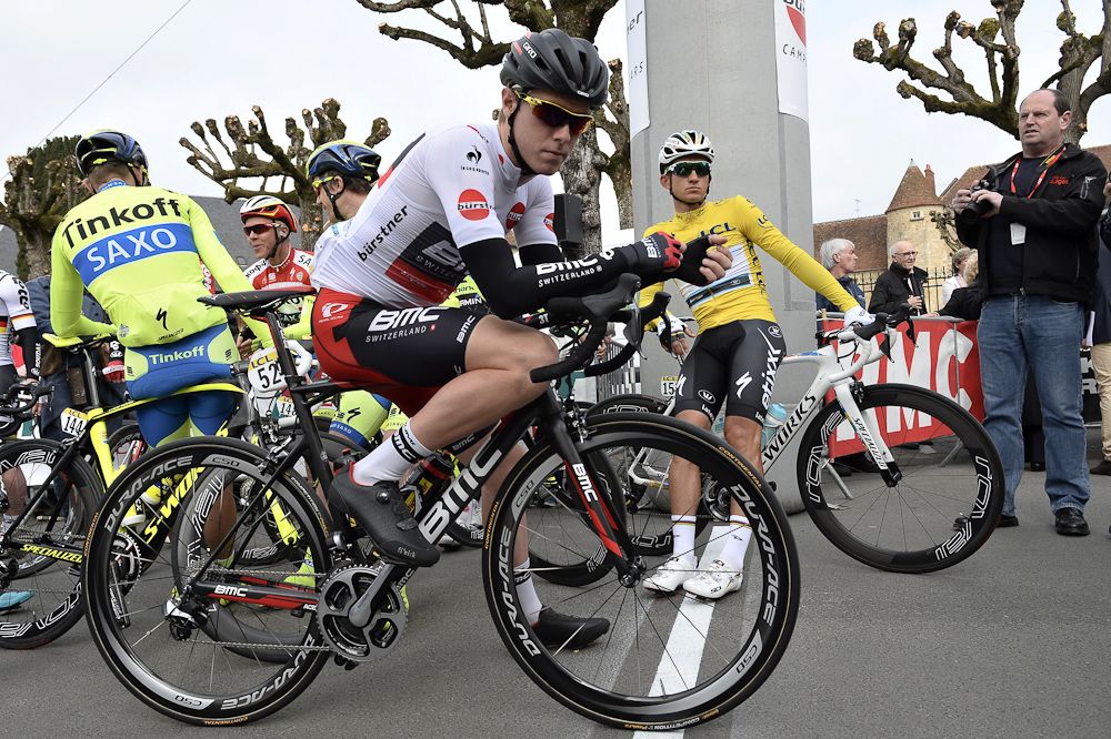 Poland's Michal Kwiatkowski (R), wearing the overall leader's yellow jersey, and Australia's Rohan Dennis (C), wearing the best young's white jersey, wait for the start of the third stage.