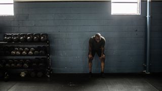 Man taking a rest between weight lifting sets