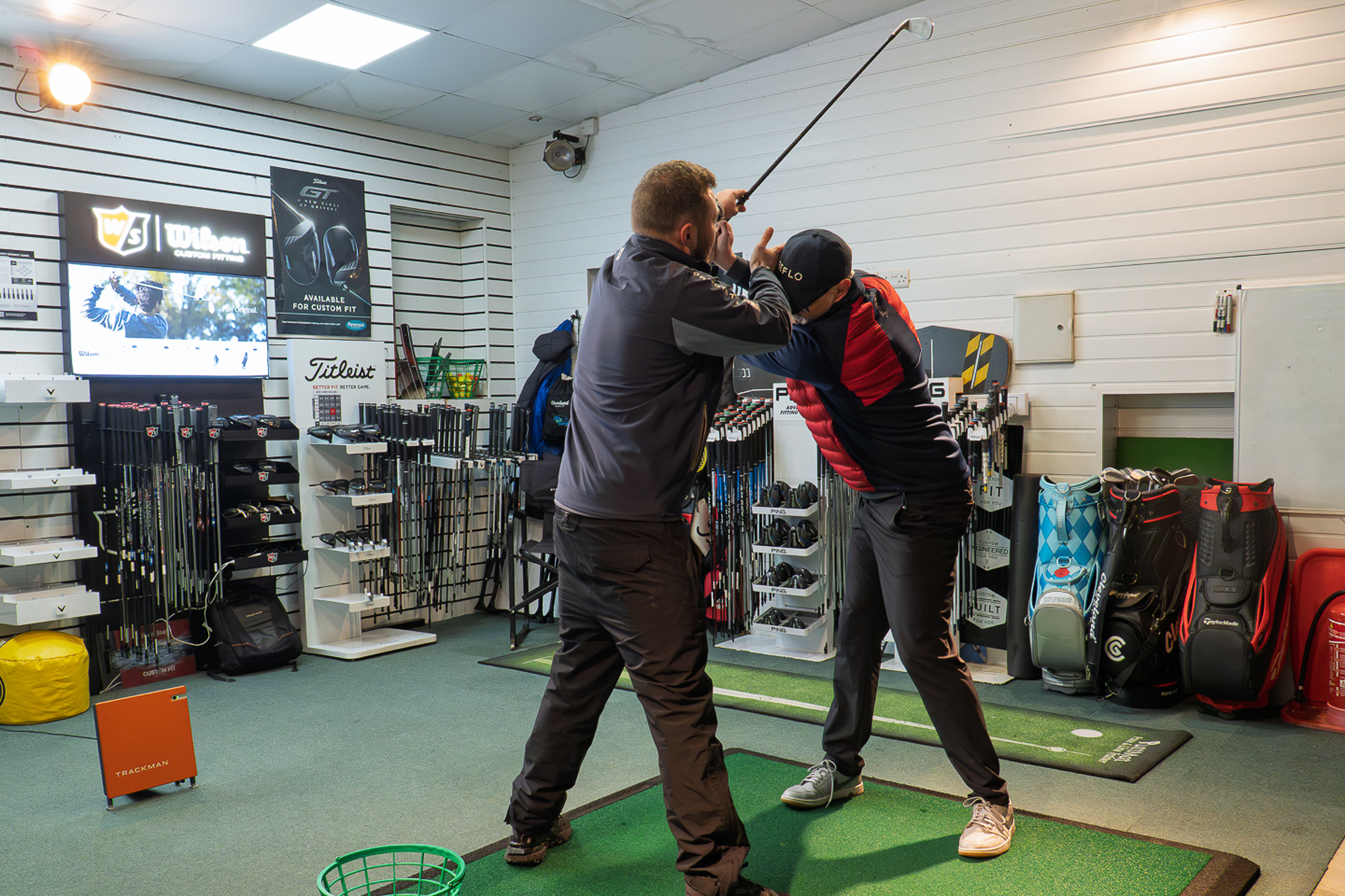 Joshua Mayo helping Rob Spedding to rotate effectively in the backswing by moving the golf club