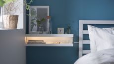 DIY bedside table: Ikea shelves used as a bedside table with integrated light in a modern bedroom with blue walls