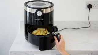 Tossing the food in an air fryer as a key step when learning how to use an air fryer