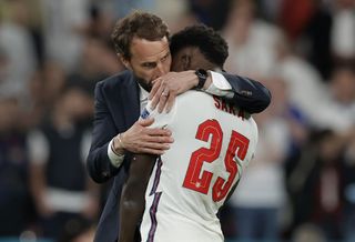 England manager Gareth Southgate hugs Bukayo Saka after his penalty miss against Italy in the final of Euro 2020.