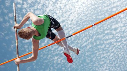 A pole vaulter clears a high bar