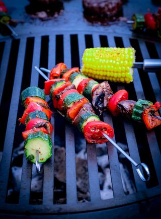 vegetable kebabs cooking on a grill
