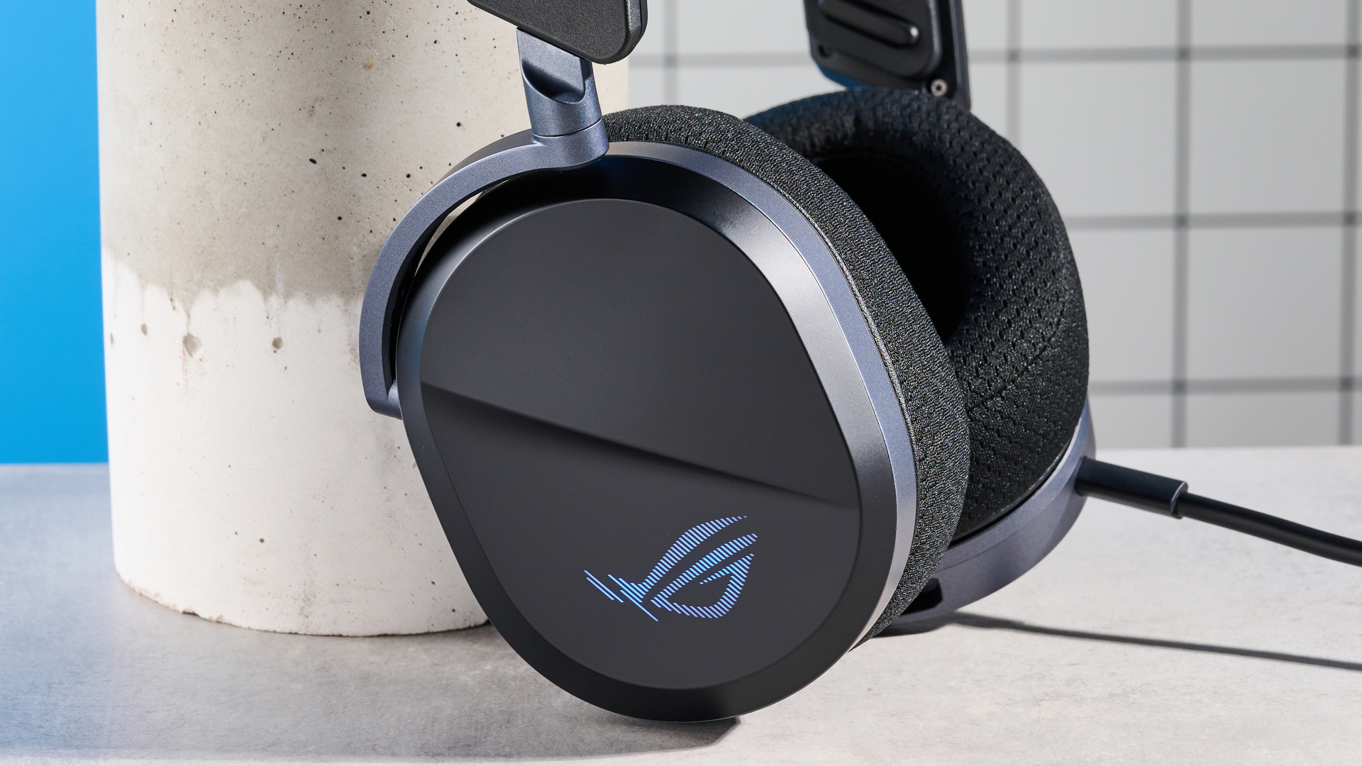 A black Asus ROG Pelta gaming headset with a detachable mic and RGB lighting
