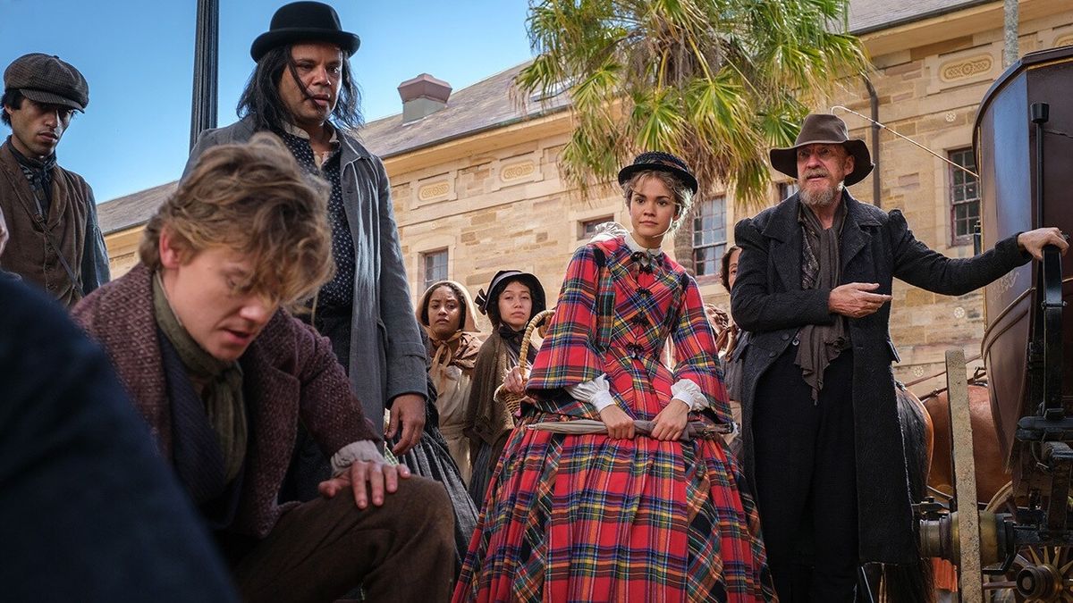 Thomas Brodie-Sangster as Artful Dodger, Maia Mitchell as Belle Fox and David Thewlis as Fagin amongst a crowd in The Artful Dodger