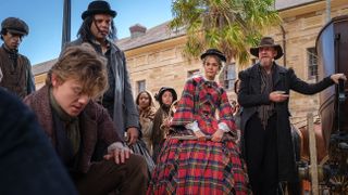 Thomas Brodie-Sangster as Artful Dodger, Maia Mitchell as Belle Fox and David Thewlis as Fagin amongst a crowd in The Artful Dodger