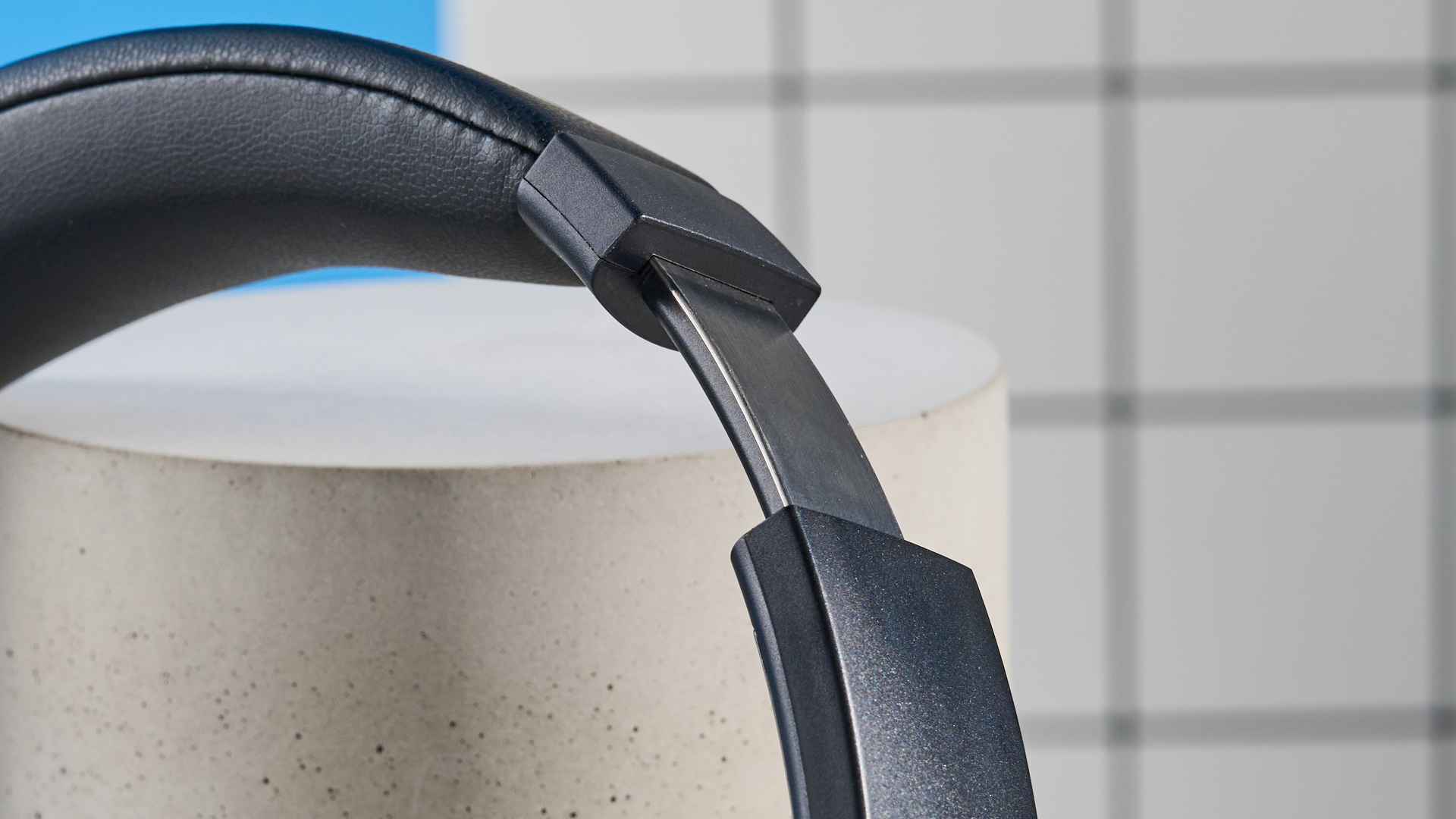 the earfun tune pro headphones, in black, with soft pleather cups, and gray cups, photographed against a blue background