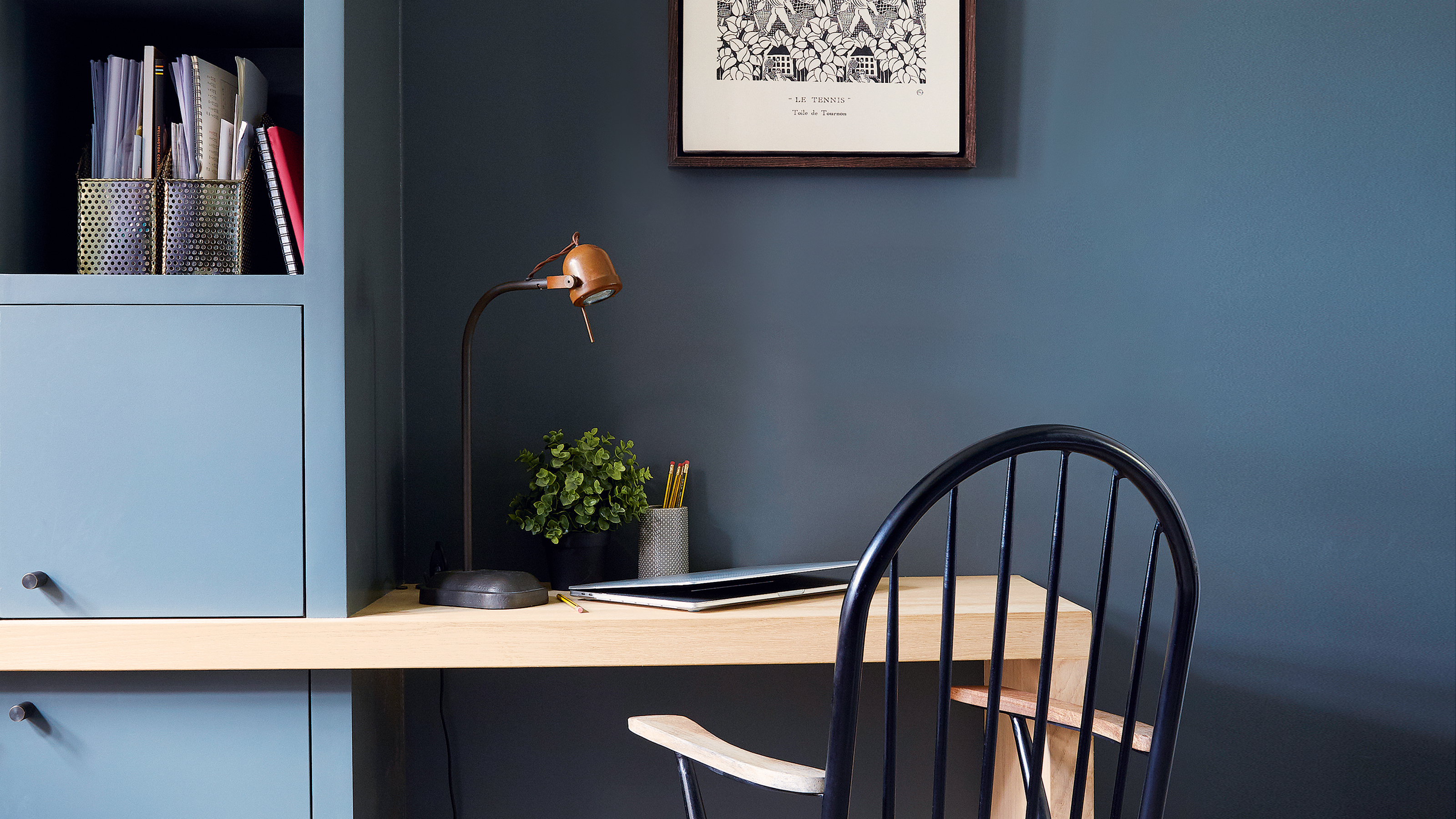 Wooden shelf extended to make desk space in navy blue room