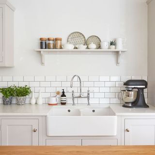 light grey and white sink area with a shelf unit and black KitchenAid