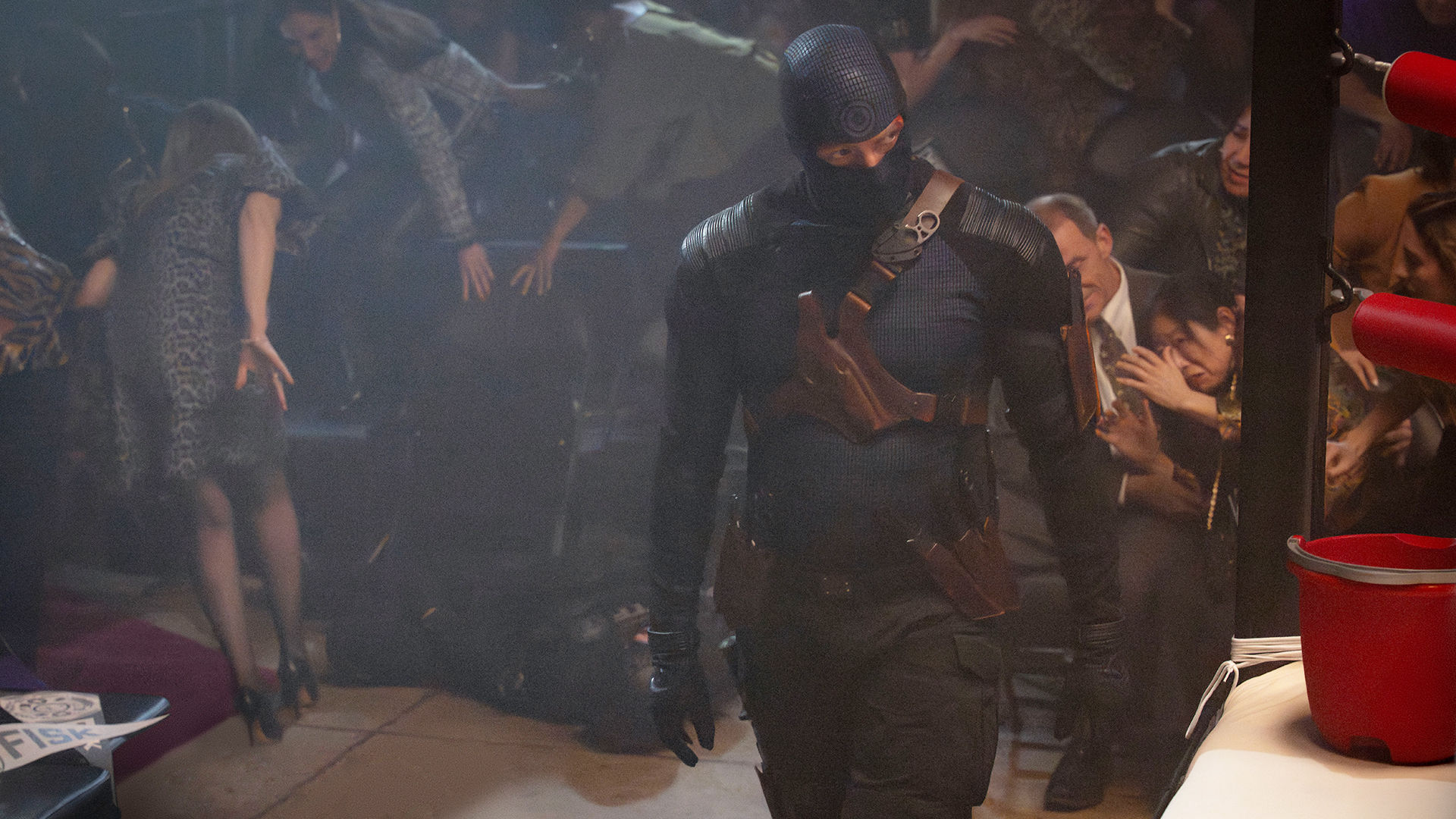 Bullseye walking alongside a boxing ring as people flee behind him in Daredevil: Born Again season 2 episode 5