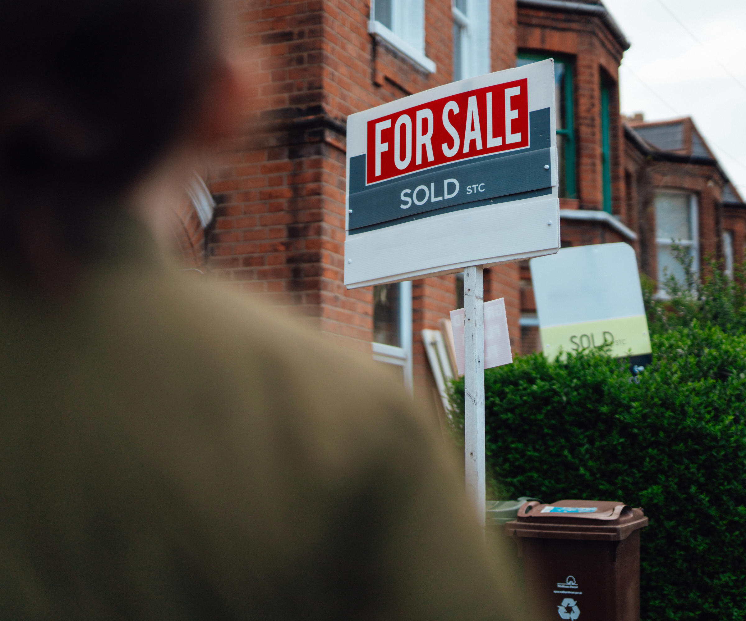 person stood looking at for sale sign with sold stc