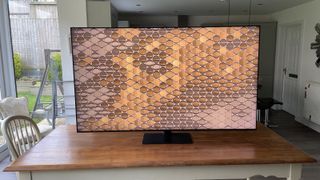 The Samsung QN95D TV photographed on a wooden table