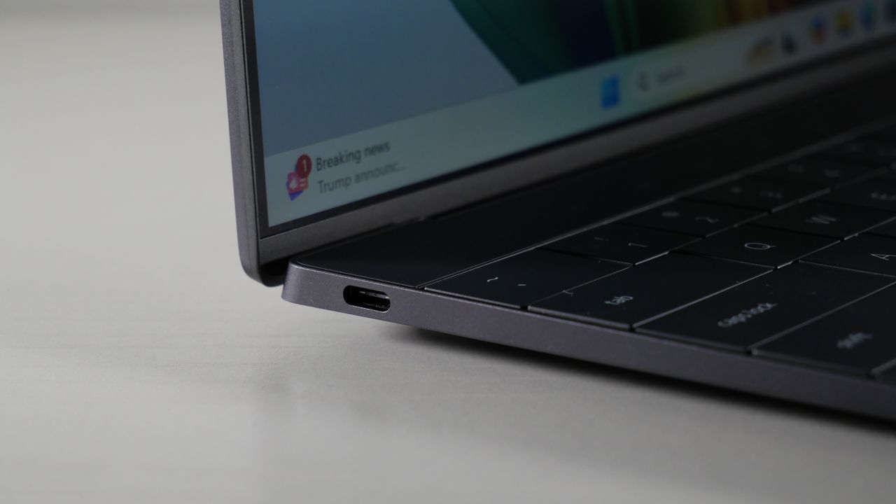 Dell XPS 13 9345 (Snapdragon X Elite) open on a white desktop with the focus on the USB-C port on its side.