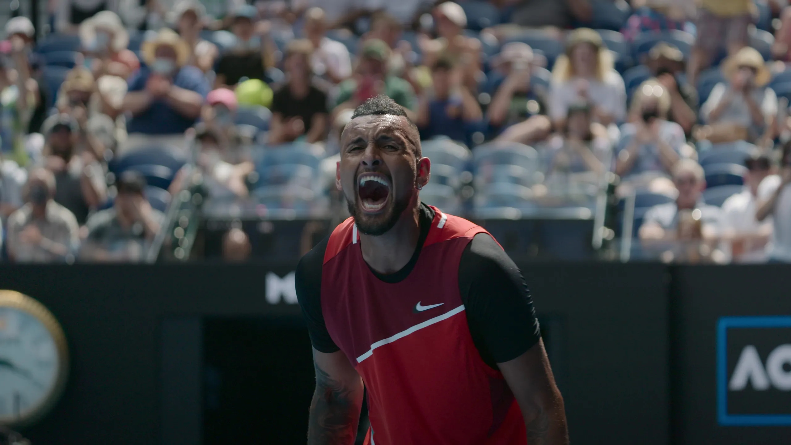 Punapaitainen Nick Kyrgios huutaa yleisön edessä