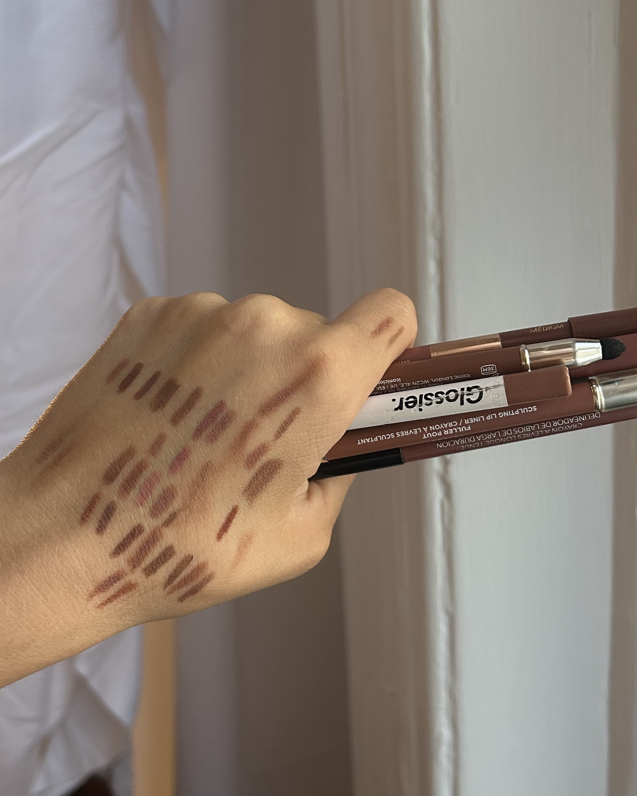 Swatches of nude lip liners on the back of Alyssa Brascia's hand.