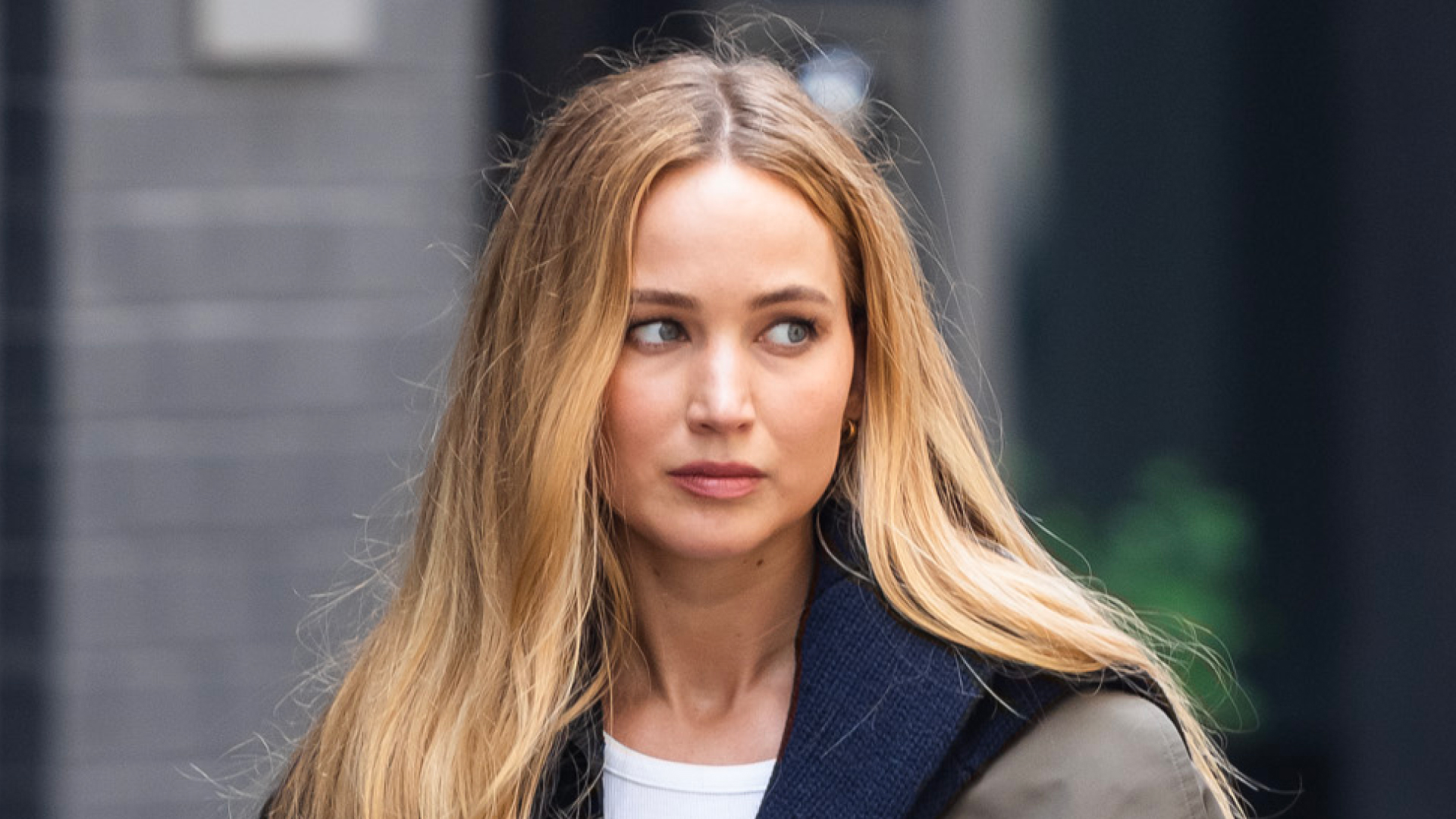 Jennifer Lawrence has long blonde hair and wears Ugg slippers and carries a Liffner basket bag