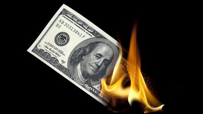 Part of a hundred-dollar bill is on fire.